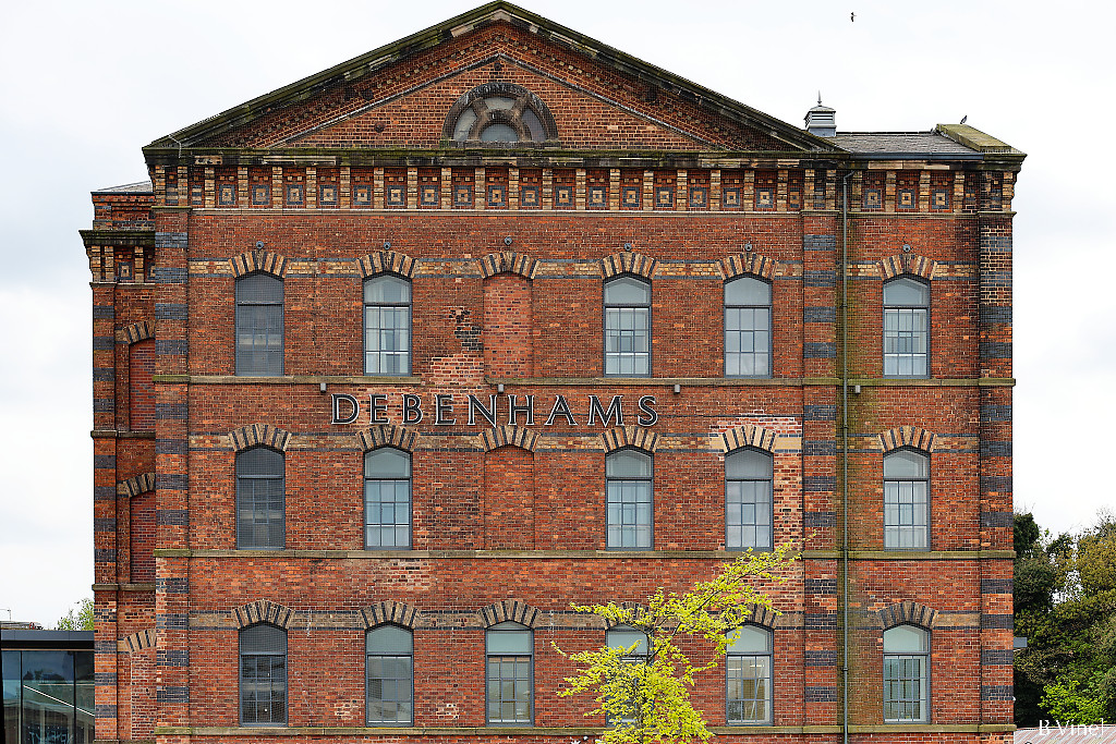 Former red brick carpet factory with the Debenhams sign