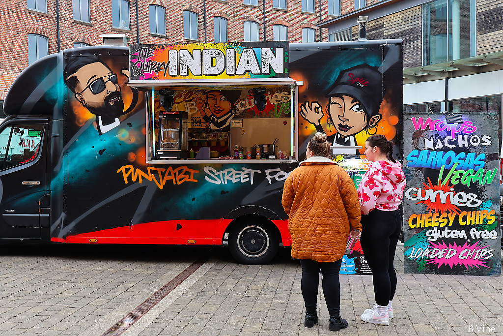 The quirky Indian street food van with painting in the style of street painting and two customers in front