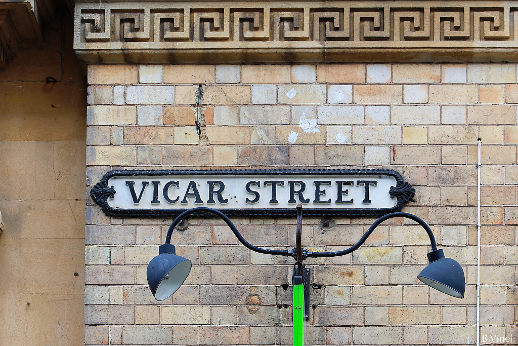 Vicar street sign on a cream brick wall