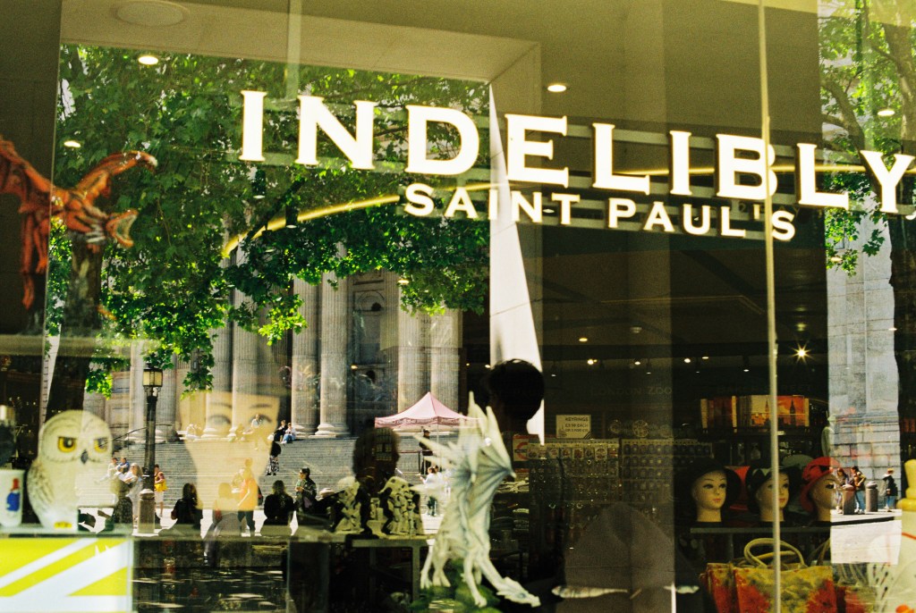 A shop window in front of St Paul's cathedral reflecting the cathedral
