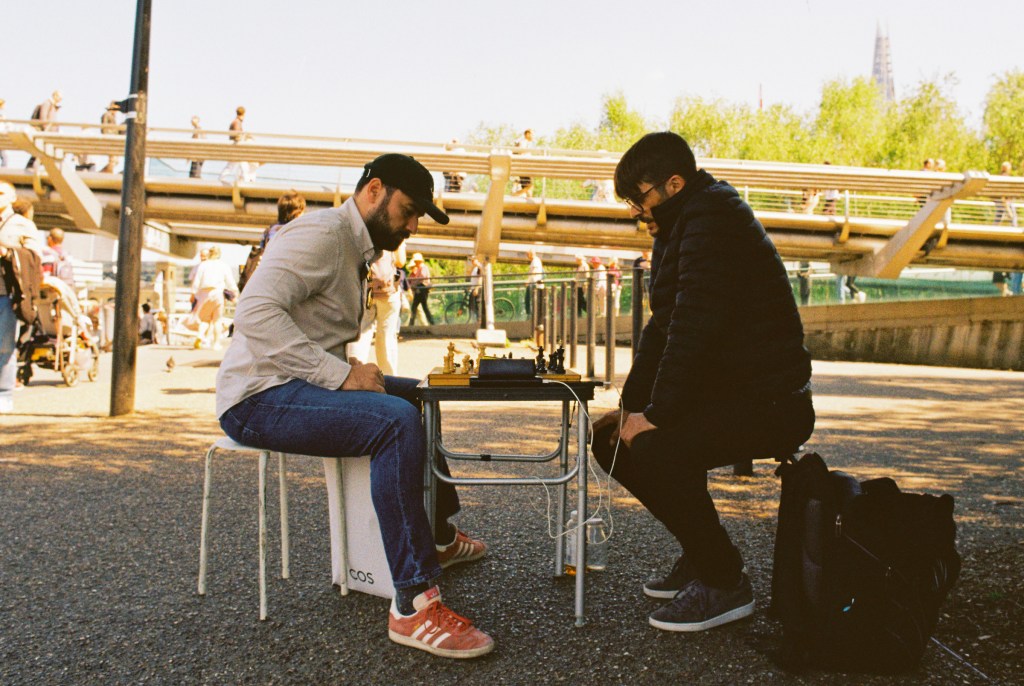 Two men playing chest in the shade of the Tate Modern