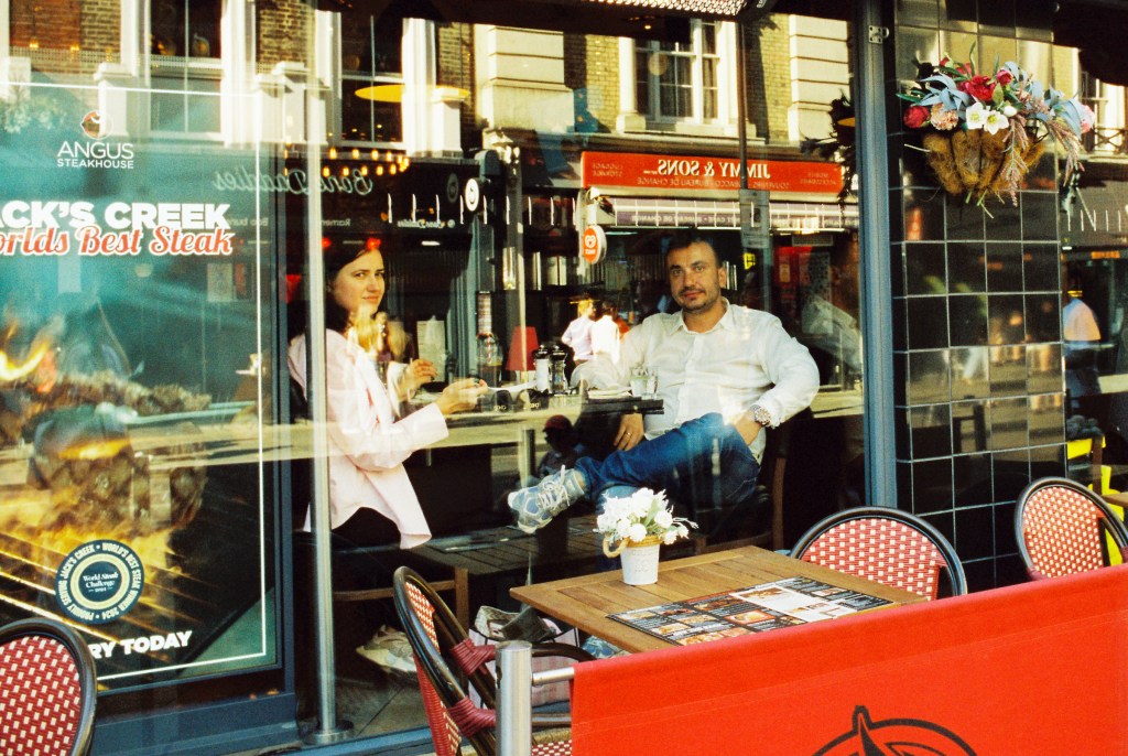 A couple having lunch behind the window of a restaurant