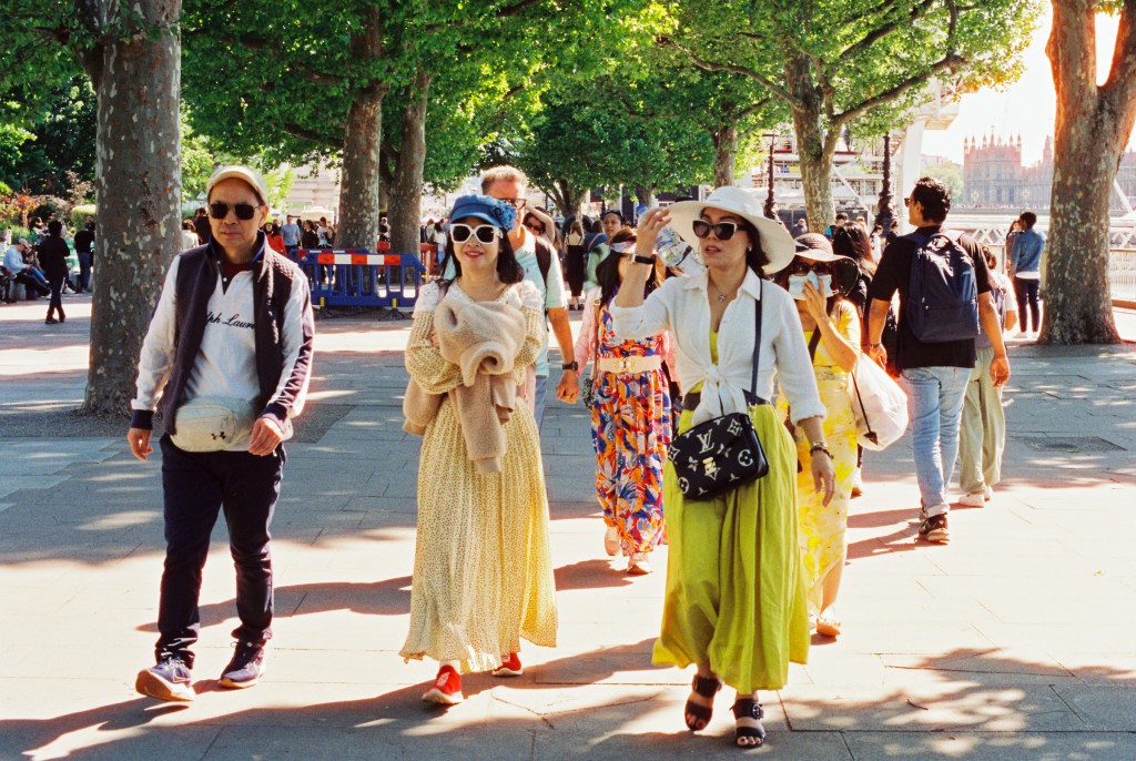 A group of tourists from asian origin walking on the Thames pathway