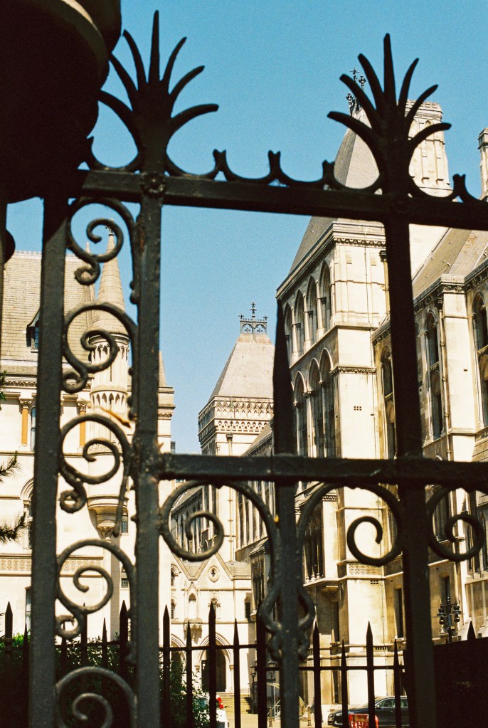The Royal Court of Justice building seen through the cast iron gate