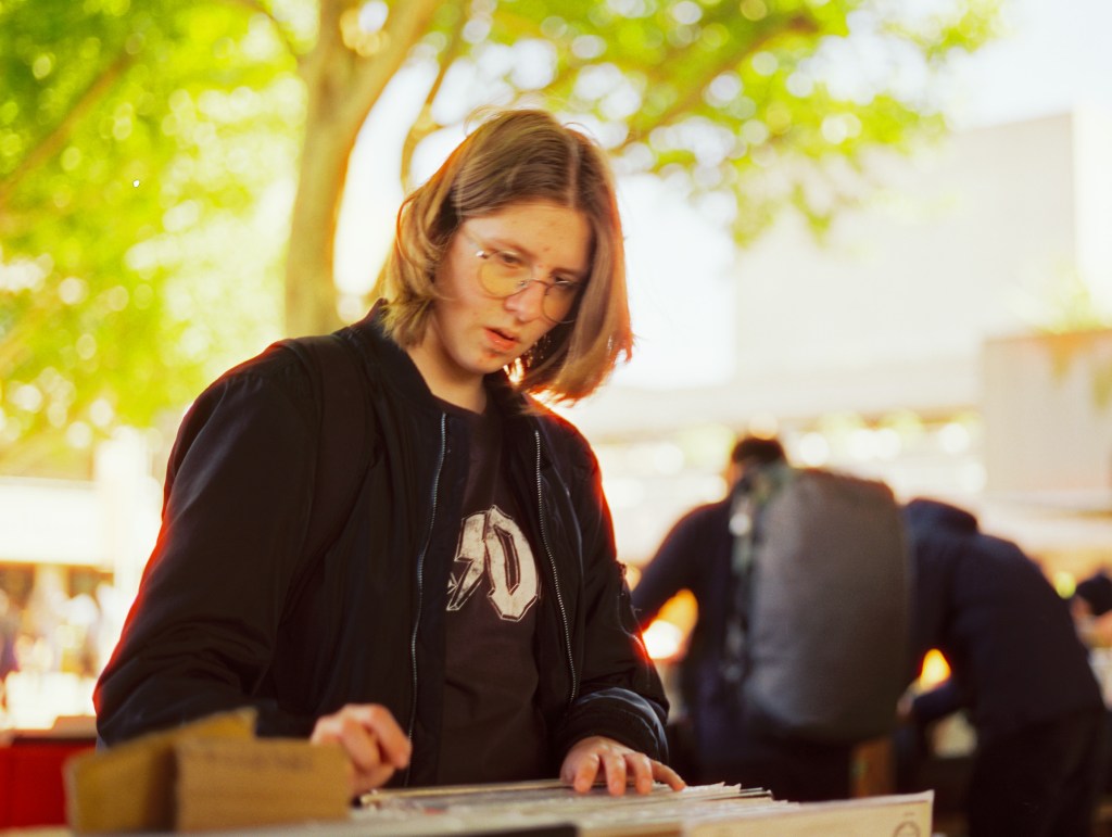 A young man is looking at LPs at the Southbank book market