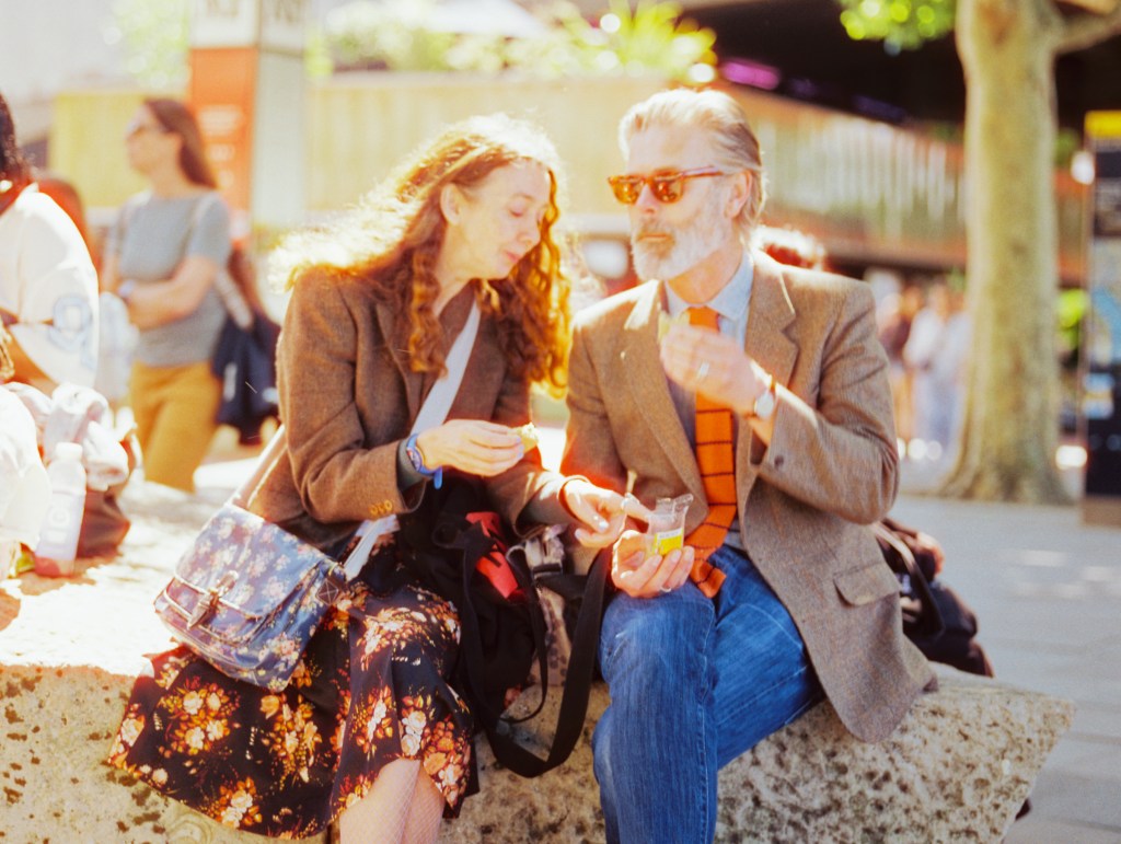 A couple well dressed are enjoying their lunch break on the Southbank boardwalk
